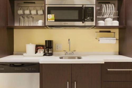 a kitchen with a sink and a microwave at Home2 Suites by Hilton Oklahoma City South in Oklahoma City