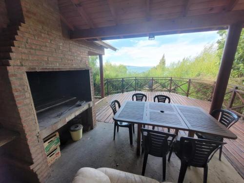 a patio with a table and chairs and a fireplace at Casa Lago Argentino in El Calafate