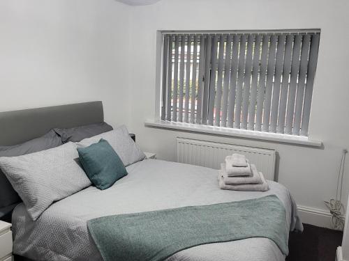 ein Schlafzimmer mit einem Bett und einem Handtuch darauf in der Unterkunft Spacious & Cosy Holiday Home in Manchester in Manchester