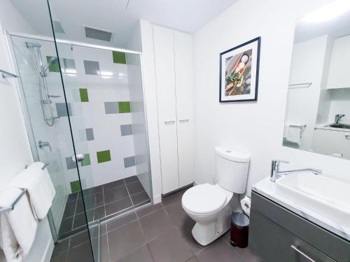 a bathroom with a toilet and a shower and a sink at Adelaide City Loft in Adelaide