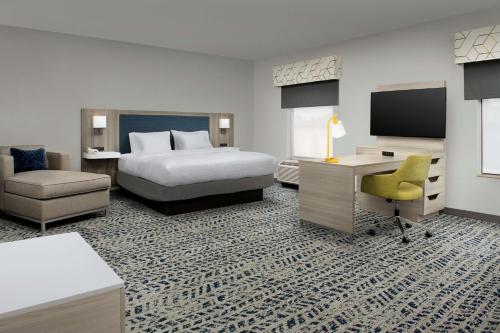 a hotel room with a bed and a desk and a tv at Hampton Inn Duncan in Duncan