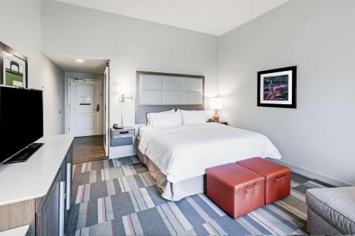 a hotel room with a bed and a flat screen tv at Hampton Inn North Little Rock McCain Mall, AR in North Little Rock