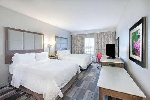 a hotel room with two beds and a television at Hampton Inn North Little Rock McCain Mall, AR in North Little Rock