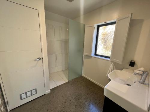 a bathroom with a sink and a shower with a window at Mary Hut in Lake Tekapo