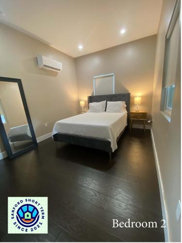 a bedroom with a large bed and a mirror at The Front Porch in Sanford