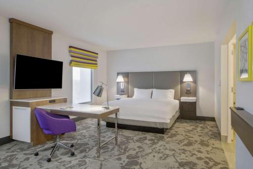 a hotel room with a bed and a desk and a tv at Hampton Inn & Suites Raleigh-Durham Airport-Brier Creek in Raleigh