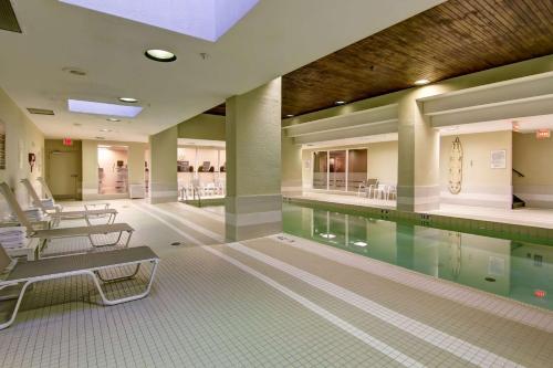 a swimming pool in a building with chairs around it at DoubleTree by Hilton Toronto Downtown in Toronto