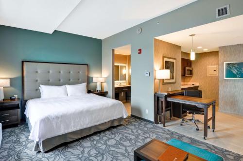 スケネクタディにあるHomewood Suites By Hilton Schenectadyのベッド、デスク、デスクが備わる客室です。