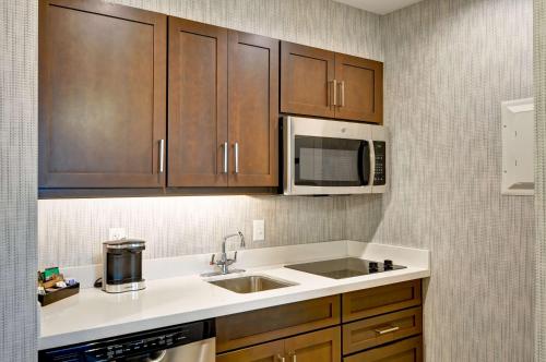 eine Küche mit einer Spüle und einer Mikrowelle in der Unterkunft Homewood Suites By Hilton Schenectady in Schenectady