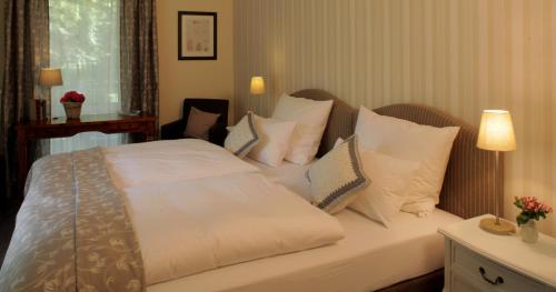 um quarto com uma cama com lençóis brancos e almofadas em Haus Geistmeier em Lippstadt