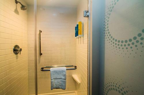 a bathroom with a shower with a towel at Tru By Hilton Norfolk Airport, Va in Virginia Beach