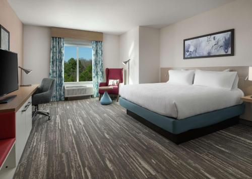 una camera d'albergo con letto e TV di Hilton Garden Inn Olive Branch, Ms a Olive Branch