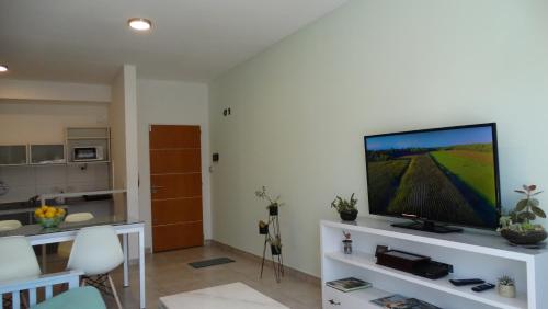 een woonkamer met een flatscreen-tv op een wit entertainmentcentrum bij Departamento de dos ambientes a 60 metros de la plaza de Adrogué in Adrogué