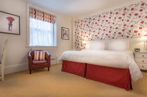 a bedroom with a large bed and a chair at Balincourt in Bournemouth