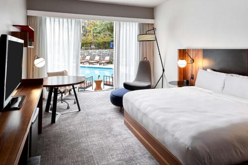 DoubleTree by Hilton Atlanta Northwest/Marietta في أتلانتا: غرفة في الفندق بسرير ومكتب وطاولة