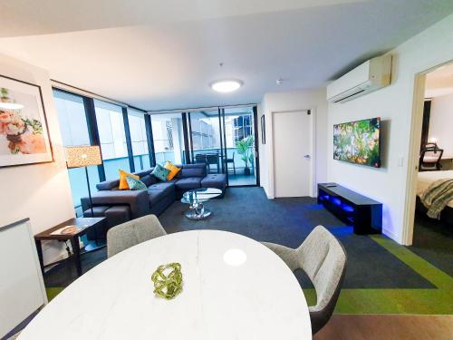 een woonkamer met een witte tafel en een bank bij Adelaide City Loft in Adelaide