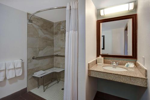 a bathroom with a sink and a shower with a mirror at Hilton Garden Inn Fort Myers in Fort Myers