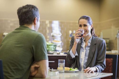 a man and a woman sitting at a table drinking wine at Homewood Suites by Hilton Waco in Waco