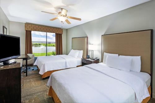 a hotel room with two beds and a flat screen tv at Homewood Suites by Hilton Waco in Waco