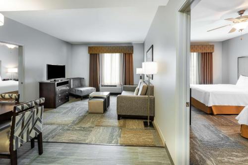 a hotel room with a bed and a living room at Homewood Suites by Hilton Waco in Waco