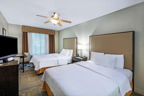 a hotel room with two beds and a flat screen tv at Homewood Suites by Hilton Waco in Waco