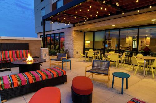 a patio with tables and chairs and a restaurant at Home2 Suites By Hilton Roseville Sacramento in Roseville