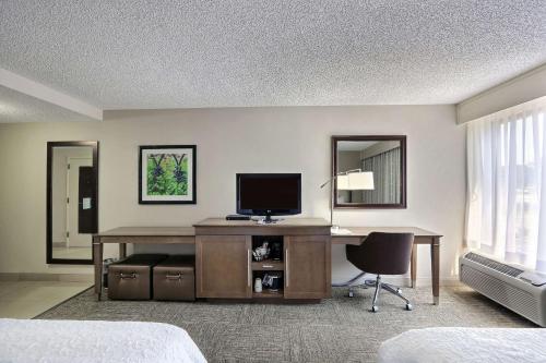 a hotel room with a desk with a computer and a bed at Hampton Inn Savannah-I-95/Richmond Hill in Richmond Hill
