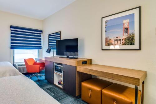 a room with a desk with a tv and a bed at Hampton Inn Johnson City in Johnson City