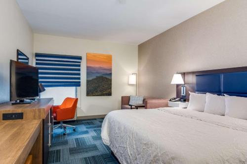 a hotel room with a bed and a flat screen tv at Hampton Inn Johnson City in Johnson City