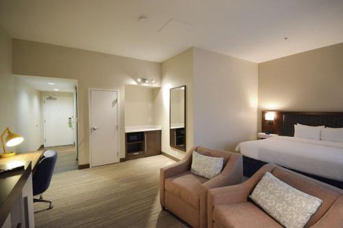 Habitación de hotel con cama, sofá y silla en Hampton Inn Salem East - Electric Road, en Salem