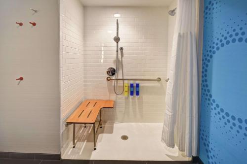 a shower with a wooden bench in a bathroom at Tru By Hilton Pigeon Forge in Pigeon Forge