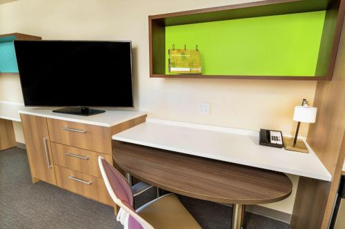 a room with a desk with a flat screen tv at Home2 Suites By Hilton Roseville Sacramento in Roseville
