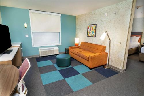 a living room with a couch and a bed at Home2 Suites By Hilton Roseville Sacramento in Roseville