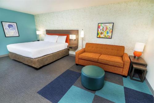 a hotel room with a bed and a couch at Home2 Suites By Hilton Roseville Sacramento in Roseville