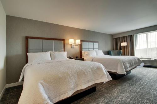 ポータケットにあるHampton Inn-Pawtucket, RIのベッド2台と窓が備わるホテルルームです。