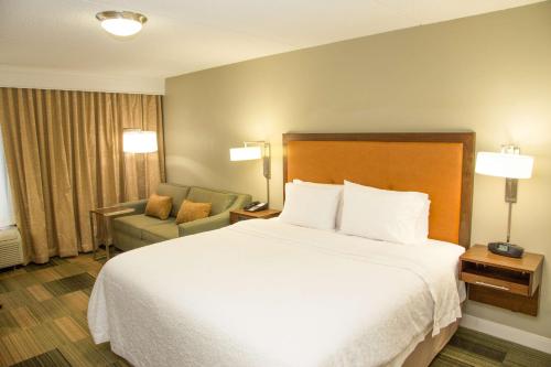 a hotel room with a bed and a chair at Hampton Inn & Suites Albany-Downtown in Albany