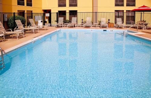 a large swimming pool with chairs and a hotel at Hampton Inn Alexandria in Alexandria
