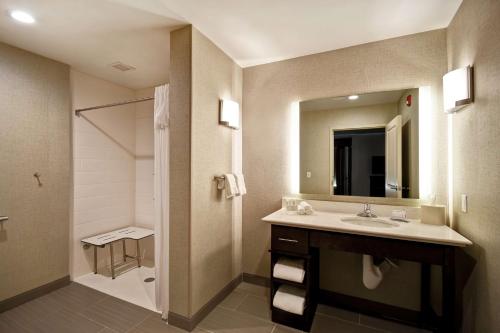 a bathroom with a sink and a shower and a mirror at Homewood Suites by Hilton Novi Detroit in Novi