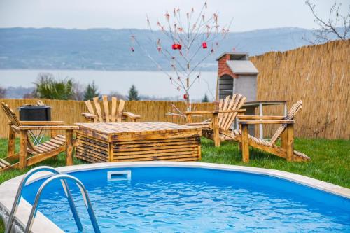 una piscina en un patio con 2 sillas y una mesa en Greenworldbungalov2, en Sapanca