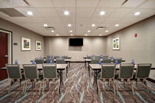 a conference room with tables and chairs and a screen at Homewood Suites by Hilton Novi Detroit in Novi