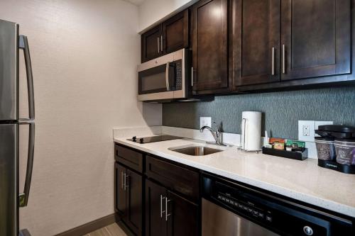 a kitchen with a sink and a microwave at Homewood Suites by Hilton Novi Detroit in Novi
