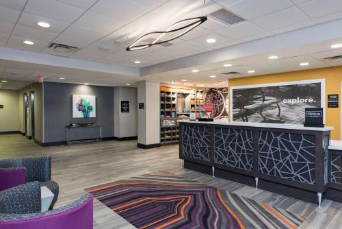 a lobby of a store with purple chairs and a counter at Hampton Inn & Suites West Lafayette, In in West Lafayette