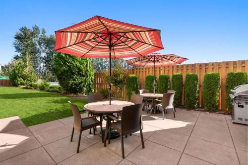 two tables and chairs with umbrellas on a patio at Hampton Inn & Suites Burlington in Burlington