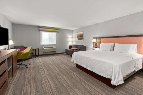 um quarto de hotel com uma cama e uma televisão em Hampton Inn & Suites Burlington em Burlington