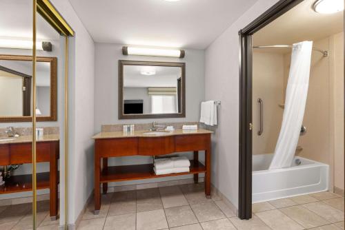 a bathroom with two sinks and a tub and a shower at Hampton Inn & Suites Burlington in Burlington