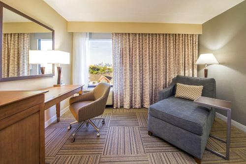 Cette chambre d'hôtel dispose d'un bureau, d'une chaise et d'une fenêtre. dans l'établissement Hampton Inn Philadelphia-Airport, à Philadelphie