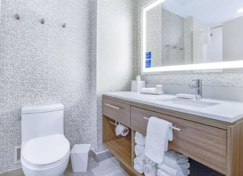 a bathroom with a toilet and a sink with a mirror at Home2 Suites By Hilton Daphne Spanish Fort in Daphne