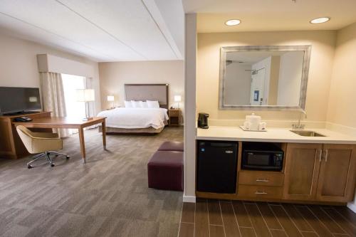 a hotel room with a bed and a bathroom at Hampton Inn & Suites - Pittsburgh/Harmarville, PA in Harmarville