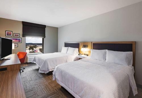a hotel room with two beds and a flat screen tv at Hampton Inn By Hilton Bulverde Texas Hill Country in Bulverde