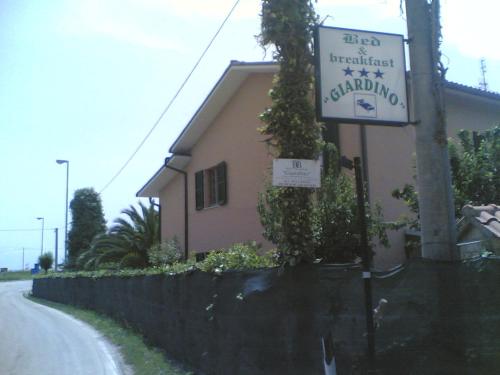 a building with a sign on the side of a road at Bed&Breakfast Giardino Agritourist in Controguerra